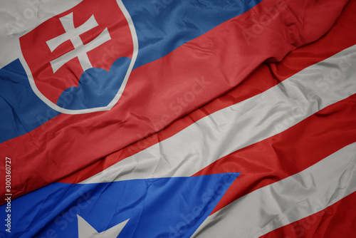 waving colorful flag of puerto rico and national flag of slovakia.