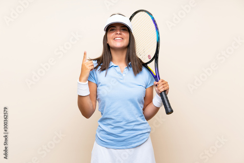 Young woman playing tennis over isolated background pointing up a great idea
