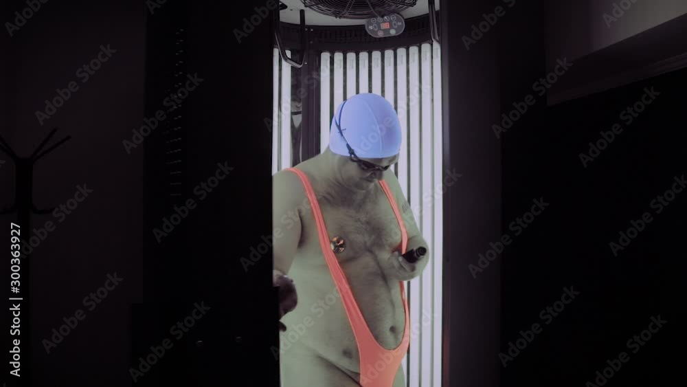 Full man comes out of the tanning booth.