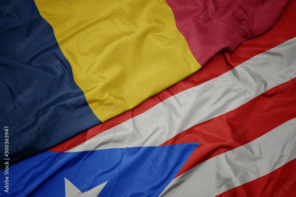 waving colorful flag of puerto rico and national flag of chad.