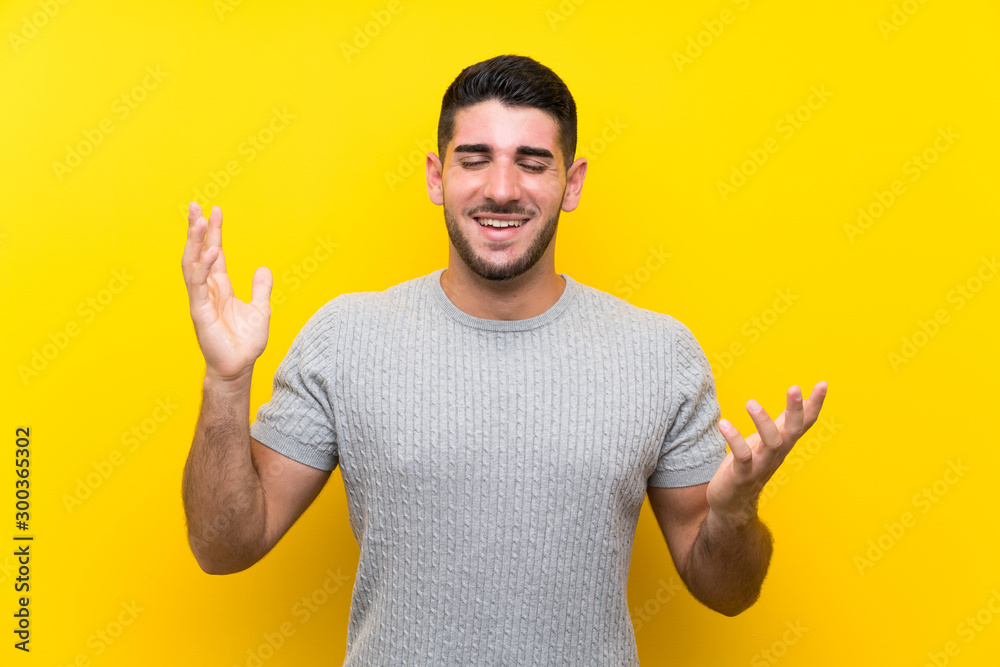 Young handsome man over isolated yellow background laughing Young handsome man over isolated yellow background laughing