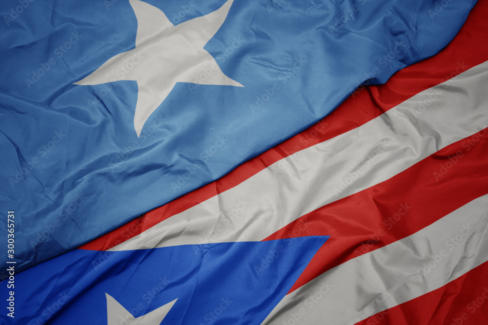 waving colorful flag of puerto rico and national flag of somalia.