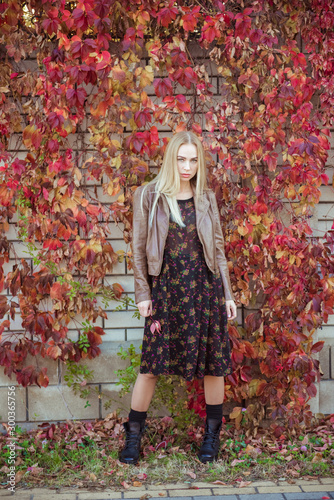 Beautiful blonde girl with autumn leaves grape portrait