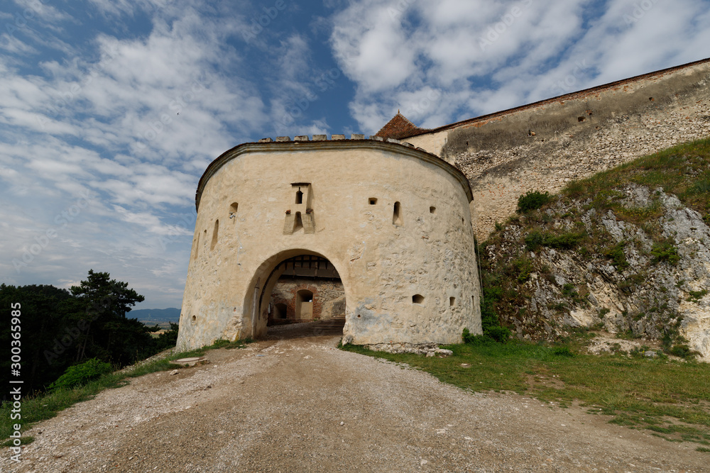 Entrance of famous Rasnov castle in Romania during a summer day with clear blue sky and white clouds (Romania, Europe)