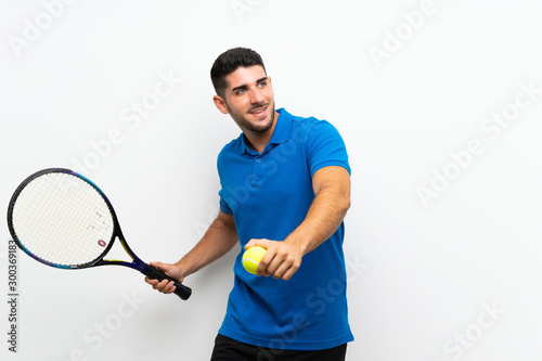 Handsome young tennis player man over isolated white wall © luismolinero