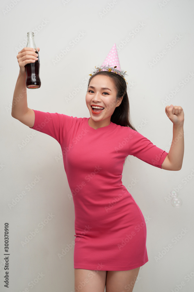 Stylish asian woman drinking soda dancing over white background Stylish asian woman drinking soda dancing over white background
