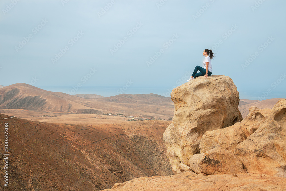 Mujer en acantilado con montañas I
