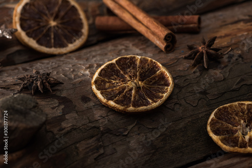 dried citrus slices with anise, cinnamon sticks on wooden background