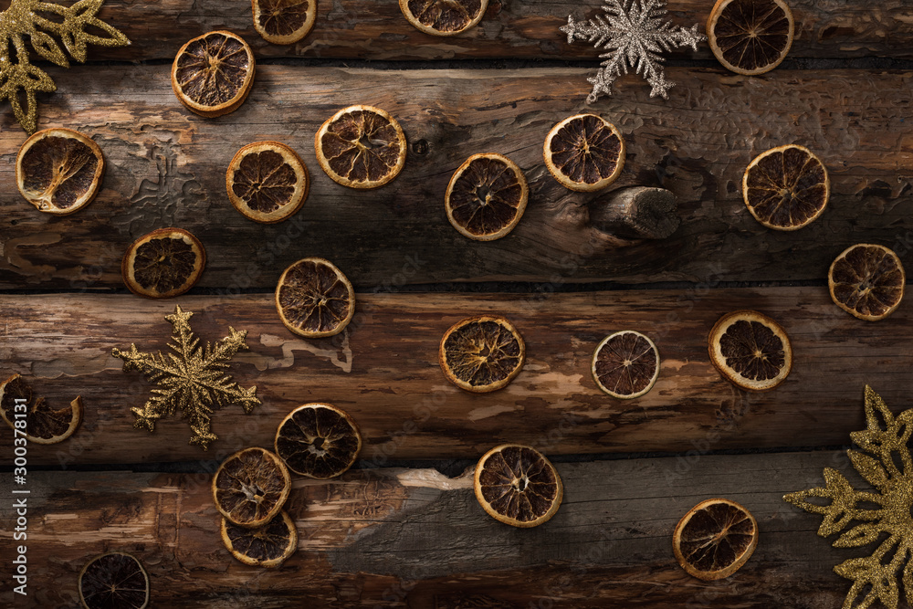top view of dried citrus slices and decorative snowflakes on wooden background top view of dried citrus slices and decorative snowflakes on wooden background