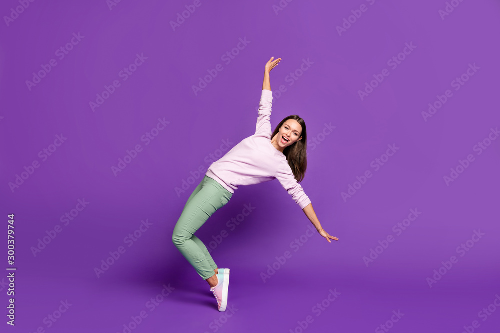 Full length body size photo of cheerful cute nice attractive girlfriend daincing while balancing on her toes with emotions on face isolated over purple vivid color background