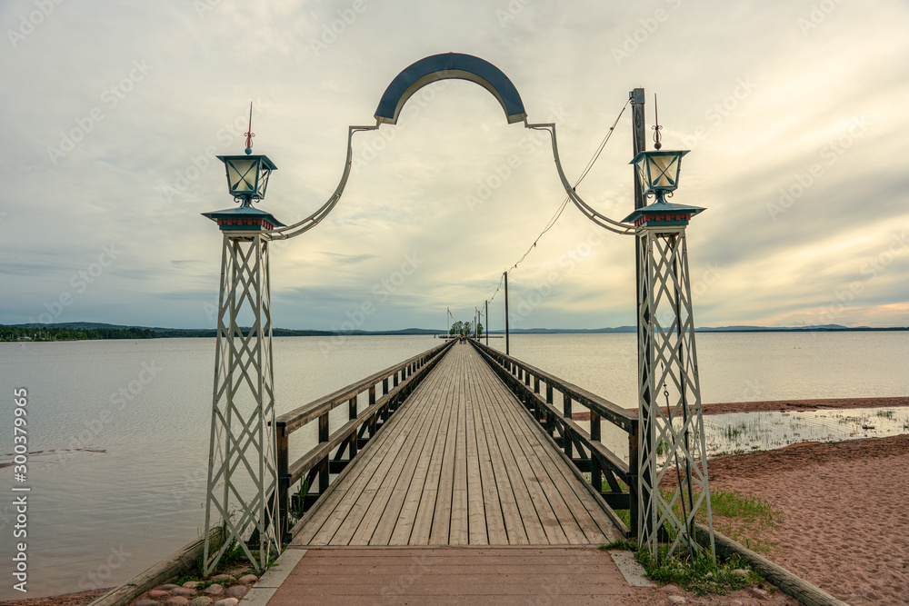Long wooden pier leading to a small island in lake Siljan in Sweden