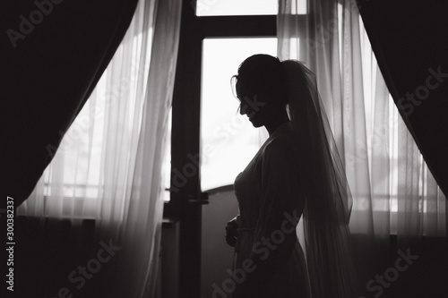 Morning of beautiful bride. Woman in white negligee in hotel