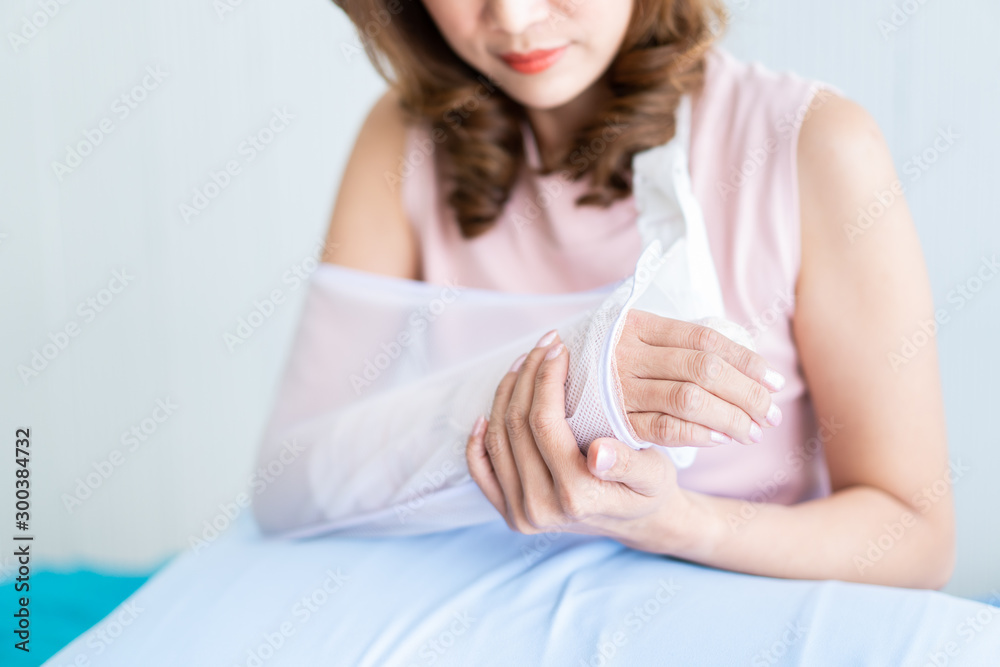 Asian woman looking at her arm that injured from accident. Concept of healthcare and wellness in adult people. Asian woman looking at her arm that injured from accident. Concept of healthcare and wellness in adult people.