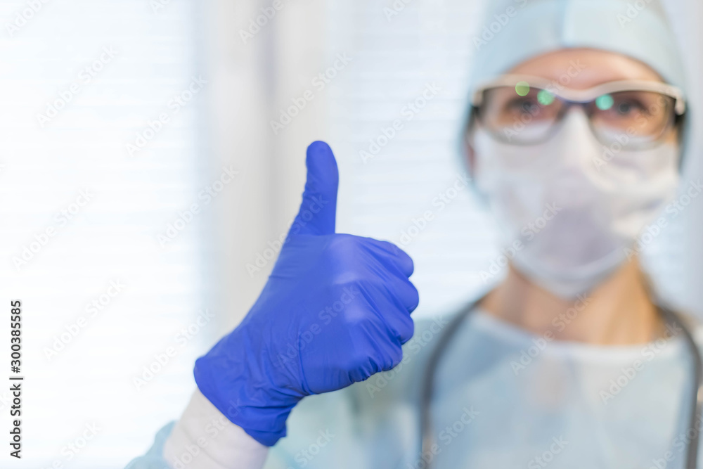 Woman doctor in mask in medical gloves show thumbs up Woman doctor in mask in medical gloves show thumbs up