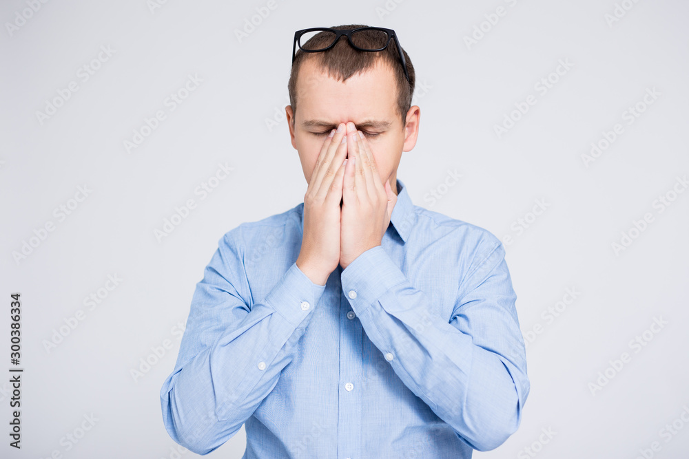 portrait of young stressed or tired businessman over gray background portrait of young stressed or tired businessman over gray background