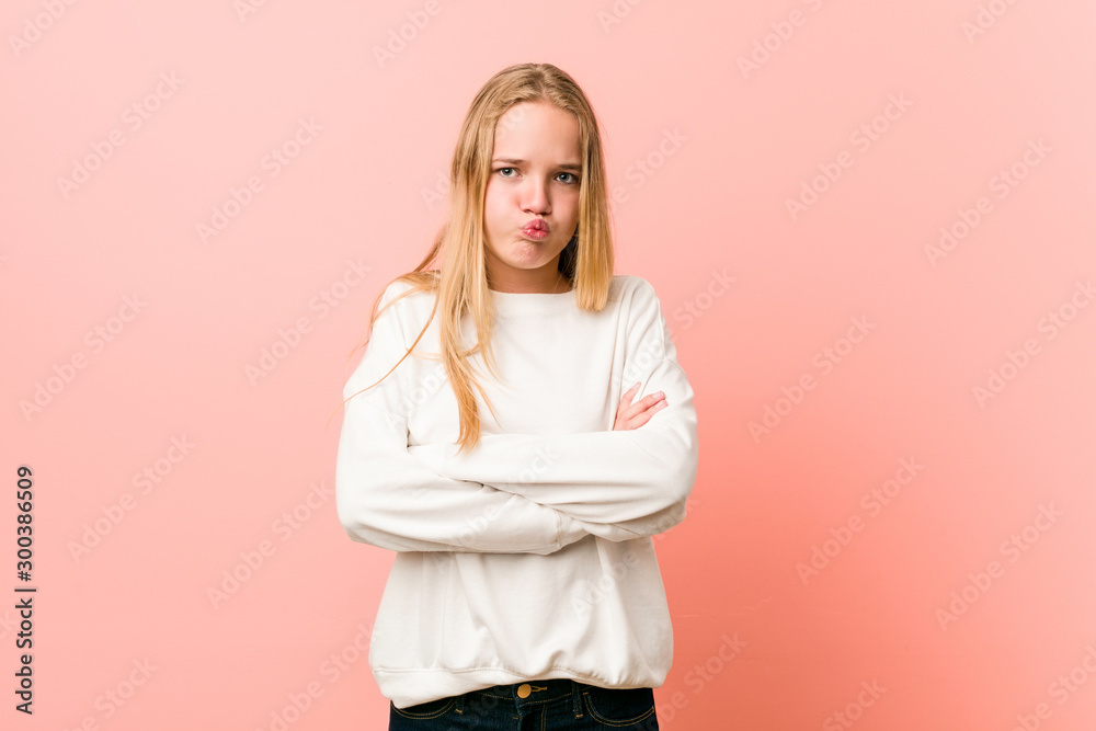 Young blonde teenager woman blows cheeks, has tired expression. Facial expression concept. Young blonde teenager woman blows cheeks, has tired expression. Facial expression concept.