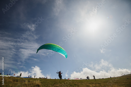 Paraglider flying over the Garda Lake,Panorama of the gorgeous Garda lake surrounded by mountains, Malcesine, Italy 