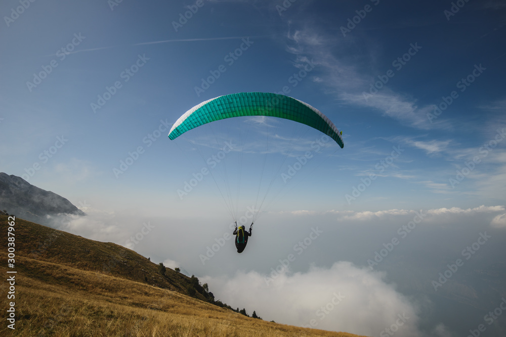 Paraglider flying over the Garda Lake,Panorama of the gorgeous Garda lake surrounded by mountains, Malcesine, Italy Paraglider flying over the Garda Lake,Panorama of the gorgeous Garda lake surrounded by mountains, Malcesine, Italy