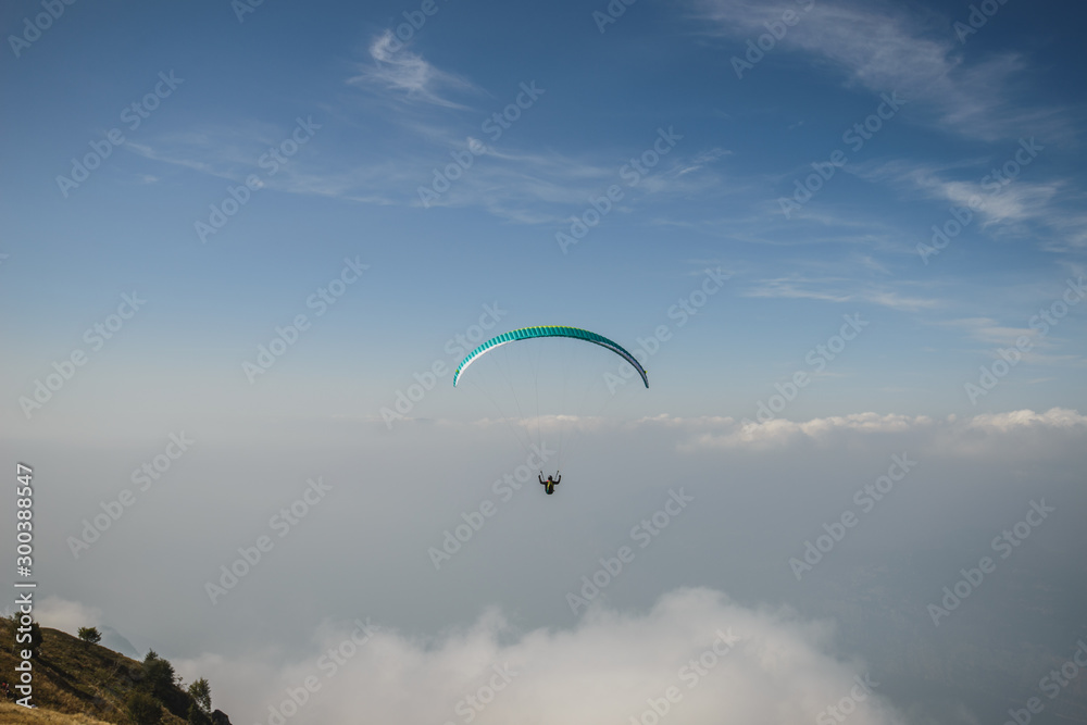 Paraglider flying over the Garda Lake,Panorama of the gorgeous Garda lake surrounded by mountains, Malcesine, Italy Paraglider flying over the Garda Lake,Panorama of the gorgeous Garda lake surrounded by mountains, Malcesine, Italy