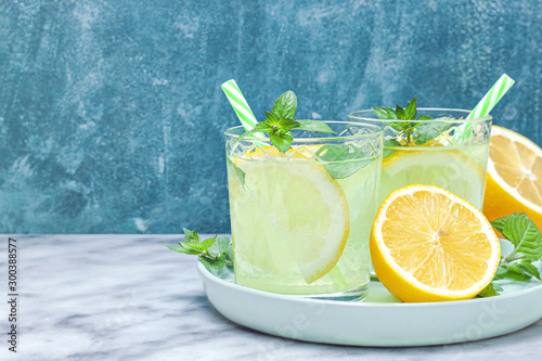 Lemon lemonade in mason jar glass ofwith lemons and straw on tab