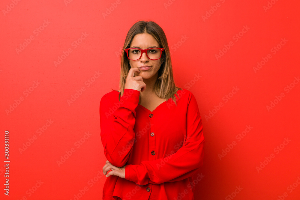 Young authentic charismatic real people woman against a wall looking sideways with doubtful and skeptical expression. Young authentic charismatic real people woman against a wall looking sideways with doubtful and skeptical expression.