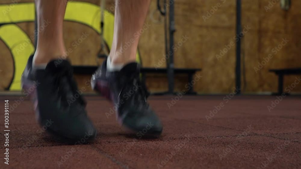 Man workout with jumping rope in crossfit gym, legs close up Man workout with jumping rope in crossfit gym, legs close up