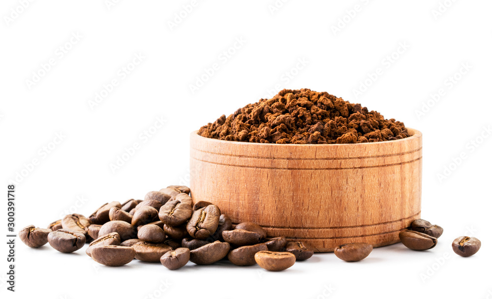 Ground coffee in a wooden plate and coffee beans on a white background. Ground coffee in a wooden plate and coffee beans on a white background.