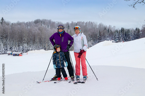 Middle aged couple on ski holiday in mountains. Older couple with grandson. photo