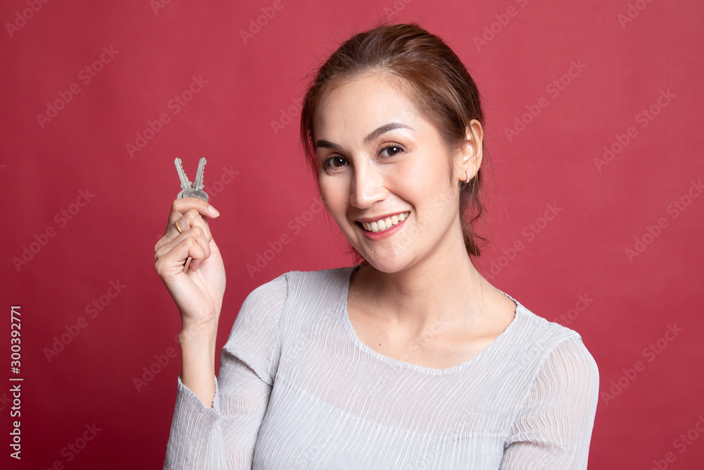 Obraz premium Cute asian girl showing home residence keys.