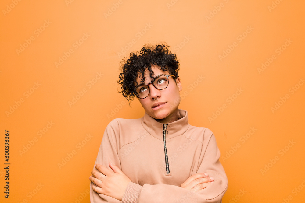 Young mixed african american woman against a brown background tired of a repetitive task.