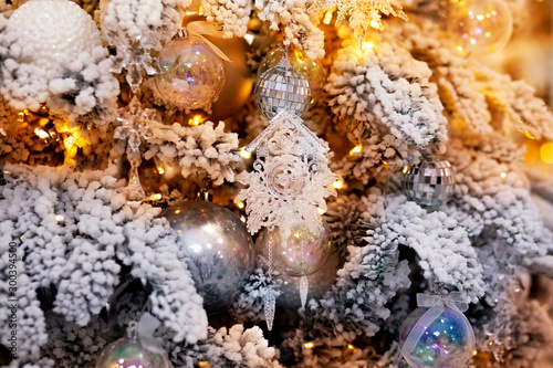Christmas white tree decorated snow illumination and gifts toys, background light bokeh