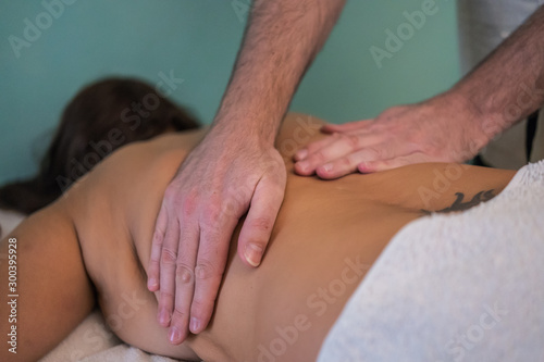  detail of adult man hands giving therapeutic massage to woman