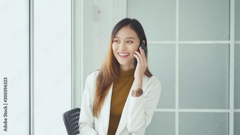 slowmotion Attractive young Asian smiling woman talking on smart phone.technology communication concept slowmotion Attractive young Asian smiling woman talking on smart phone.technology communication concept