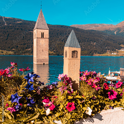 Beautiful alpine view of Lake Reschen with reflections and the famous submerged bell tower of Graun, Vinschgau, South Tyrol, Italy photo