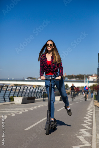 Pretty young woman riding a...