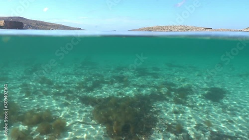 Under and Above Clear, Blue Water and stone Mountains on Malta. Dome Port underwater and sky photo