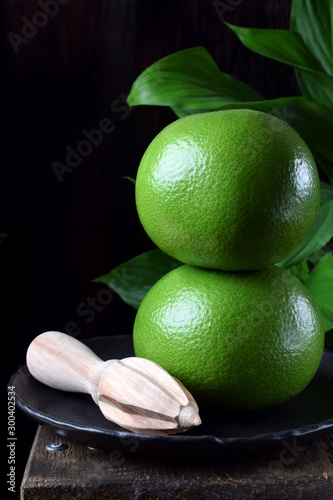 Two whole sweetie fruits against the black background