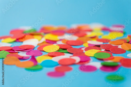 party, celebration and decoration concept - colorful confetti on blue background