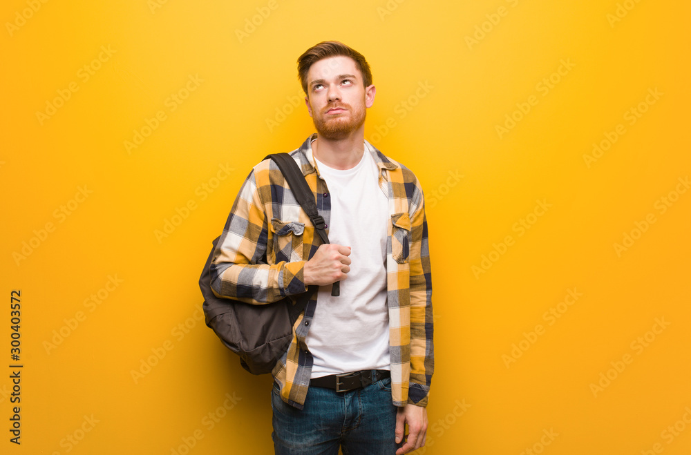 Young redhead student man tired and bored Young redhead student man tired and bored