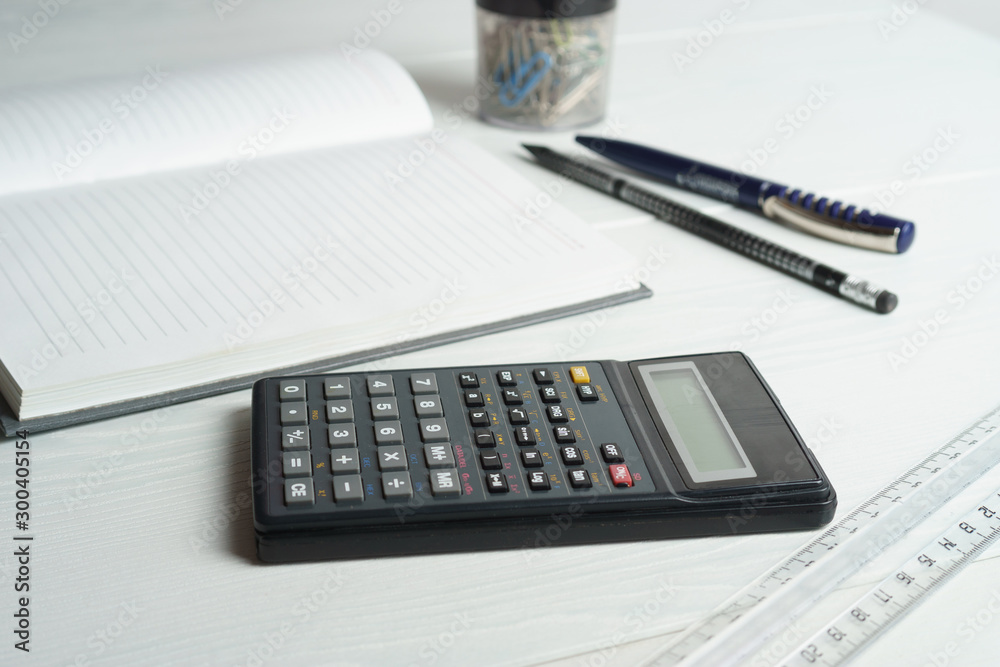 Calculator and notepad on a white table Calculator and notepad on a white table