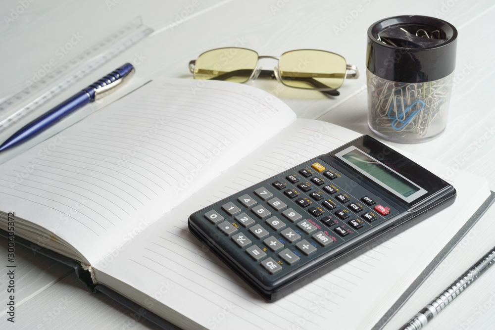 Workplace of an accountant, notebook, calculator Workplace of an accountant, notebook, calculator