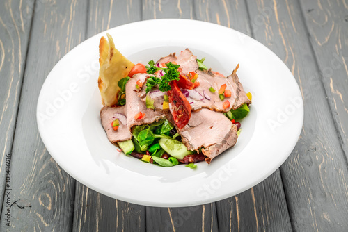 Salad leaves with sliced roast beef and sun-dried cherry tomatoes