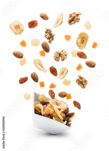 Fotografie Dried fruits jumping out white bowl on white background
