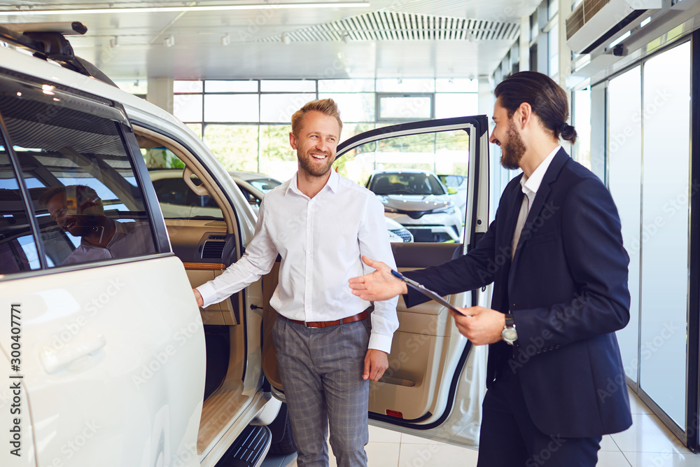 Professional salesmen selling cars at dealership to buyer Professional salesmen selling cars at dealership to buyer