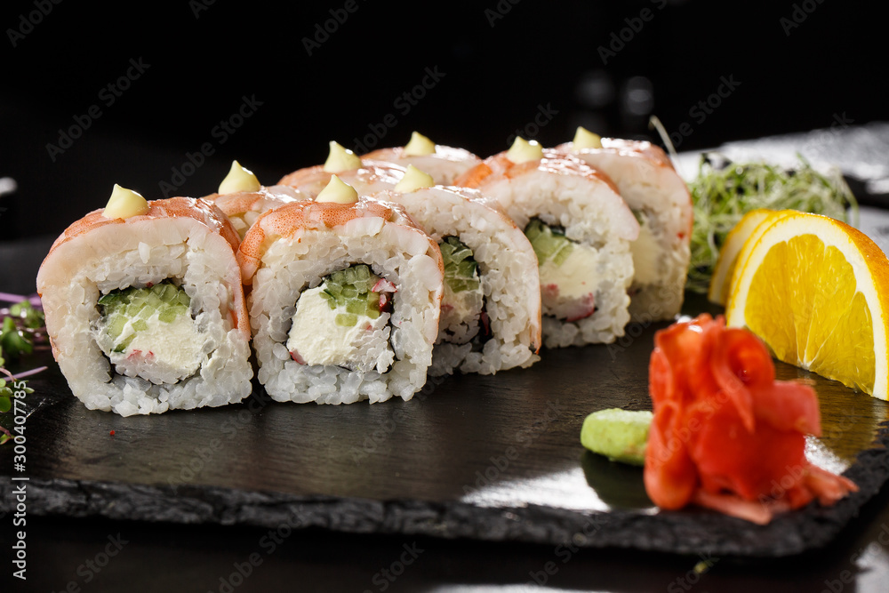 Sushi Rolls with cucumber, shrimp, crab meat and Cream Cheese inside on black slate isolated. Philadelphia roll sushi with shrimp. Sushi menu. Horizontal photo. Sushi Rolls with cucumber, shrimp, crab meat and Cream Cheese inside on black slate isolated. Philadelphia roll sushi with shrimp. Sushi menu. Horizontal photo.
