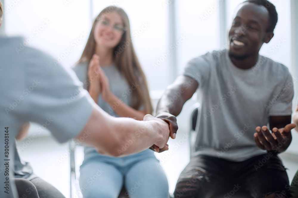 Obraz premium close up. smiling guy shaking hands with his friend