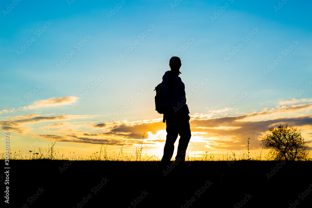Girl hiking in silhouette over the sky