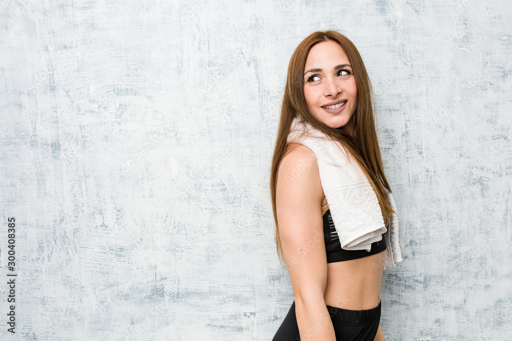 Young fitness woman looks aside smiling, cheerful and pleasant. Young fitness woman looks aside smiling, cheerful and pleasant.