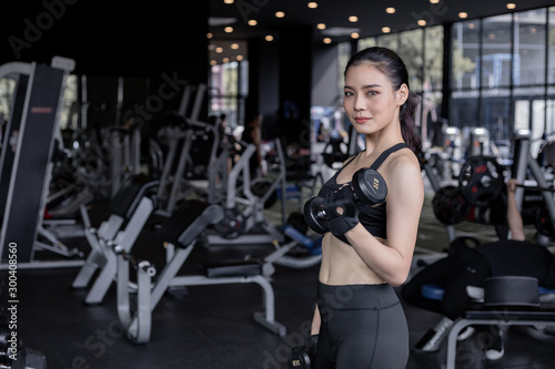 Asian women with dumbbells in the gym.