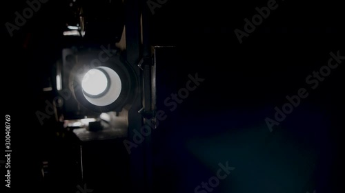 A super eight film projector on a black background, slow motion.